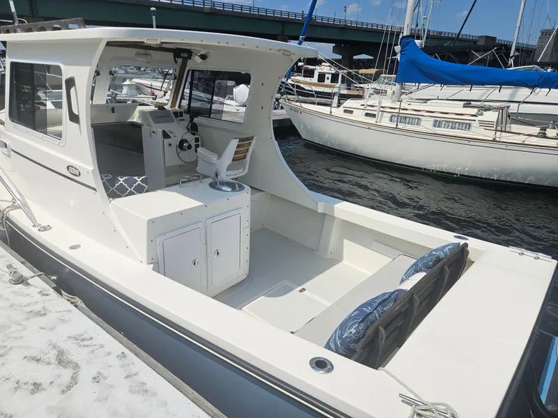 Slide: The Image of 2019 Eastern 248 Explorer boat docked at marina, featuring spacious cockpit and helm. - 19