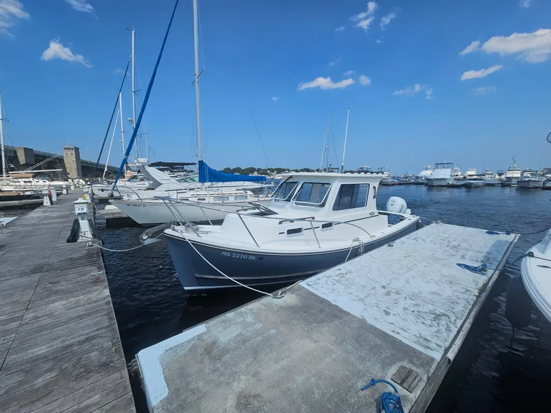 Slide: The Image of 2019 Eastern 248 Explorer boat docked at a marina under a clear blue sky. - 2