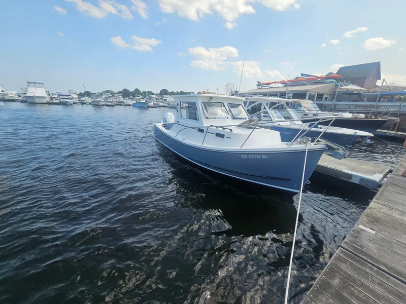 Slide: The Image of 2019 Eastern 248 Explorer boat docked at a marina under a clear sky. - 22