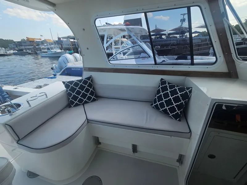 Slide: The Image of Interior of 2019 Eastern 248 Explorer boat with cushioned seating and decorative pillows. - 25