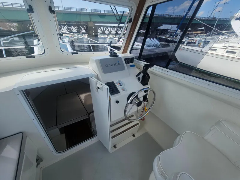 Slide: The Image of 2019 Eastern 248 Explorer boat interior with Garmin navigation, steering wheel, and cabin view. - 32