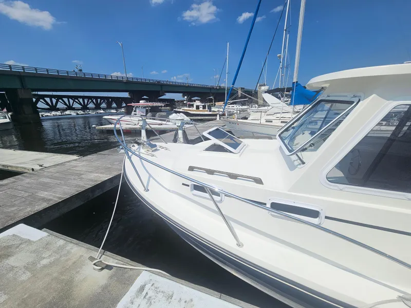 Slide: The Image of 2019 Eastern 248 Explorer boat docked near a bridge under a clear blue sky. - 4