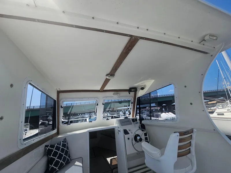 Slide: The Image of Interior of 2019 Eastern 248 Explorer boat with helm, windows, and seating. - 6