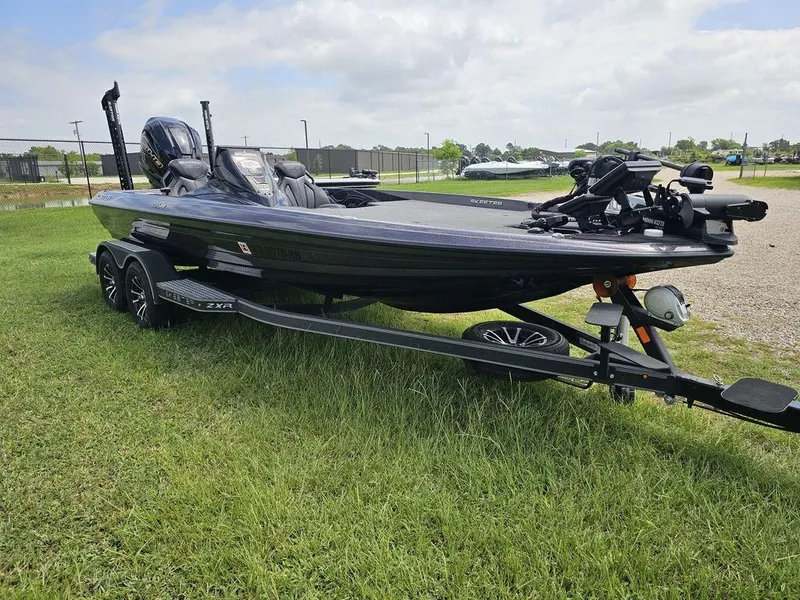 Slide: The Image of 2023 Skeeter ZXR 20 boat on trailer, parked on grass under cloudy sky. - 13