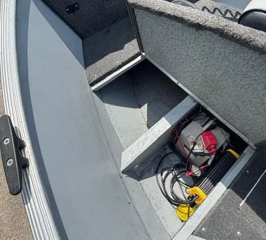 Slide: The Image of 2013 Lund 1400 Fury SS boat interior with storage compartment and battery cables. - 11