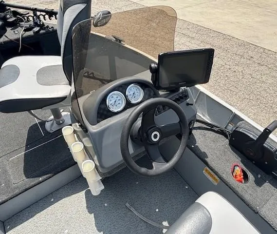 Slide: The Image of 2013 Lund 1400 Fury SS boat dashboard with steering wheel, gauges, and mounted screen. - 13