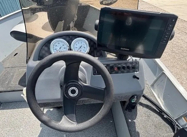 Slide: The Image of 2013 Lund 1400 Fury SS boat dashboard with steering wheel and Garmin display. - 14
