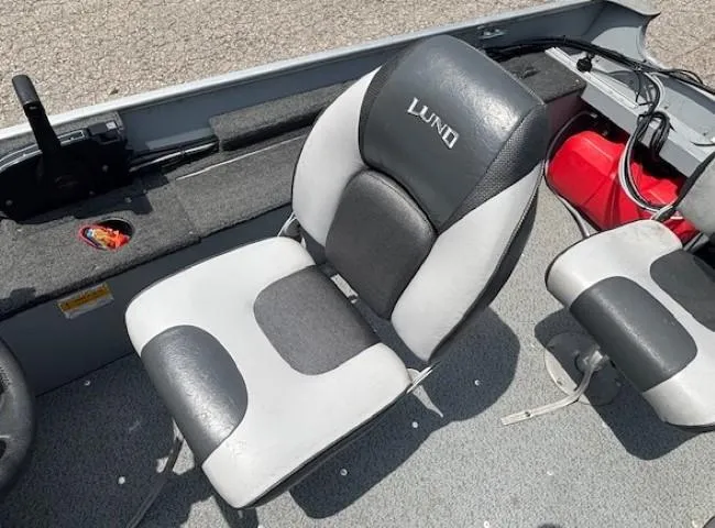 Slide: The Image of 2013 Lund 1400 Fury SS boat interior with cushioned seats and steering controls. - 15