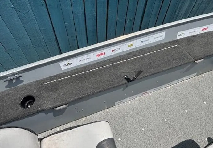 Slide: The Image of 2013 Lund 1400 Fury SS boat interior with carpeted deck and measuring ruler. - 19