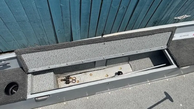 Slide: The Image of 2013 Lund 1400 Fury SS boat storage compartment with open lid, showing interior space. - 20