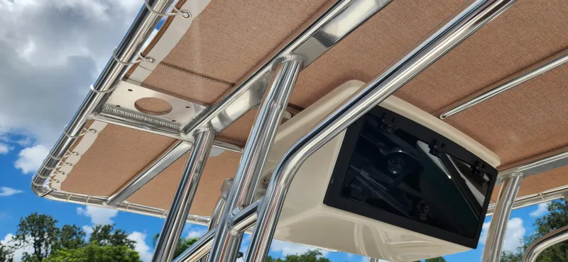 Slide: The Image of 2026 Pioneer 202 Sportfish boat T-top with electronics box under clear blue sky. - 11