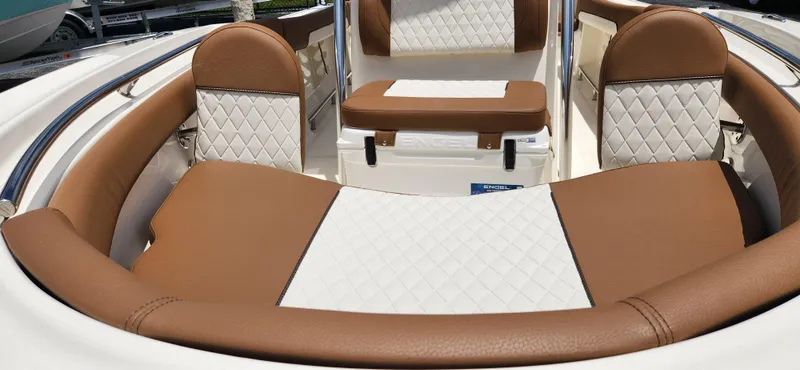 Slide: The Image of 2026 Pioneer 202 Sportfish boat interior with brown and white quilted seating. - 13