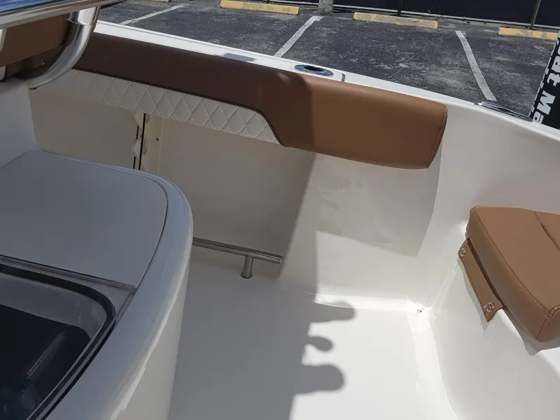 Slide: The Image of Interior of 2026 Pioneer 202 Sportfish boat with brown seating and white deck. - 15