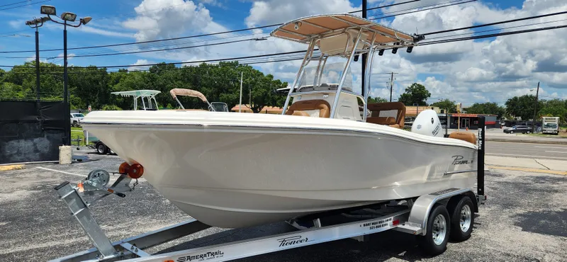 Slide: The Image of 2026 Pioneer 202 Sportfish boat on trailer, parked outdoors under a clear blue sky. - 16