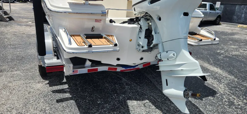 Slide: The Image of 2026 Pioneer 202 Sportfish boat rear view with outboard motor and trailer. - 3