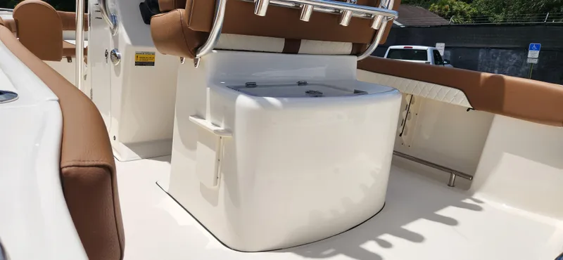 Slide: The Image of 2026 Pioneer 202 Sportfish boat interior with tan seating and storage compartment. - 5