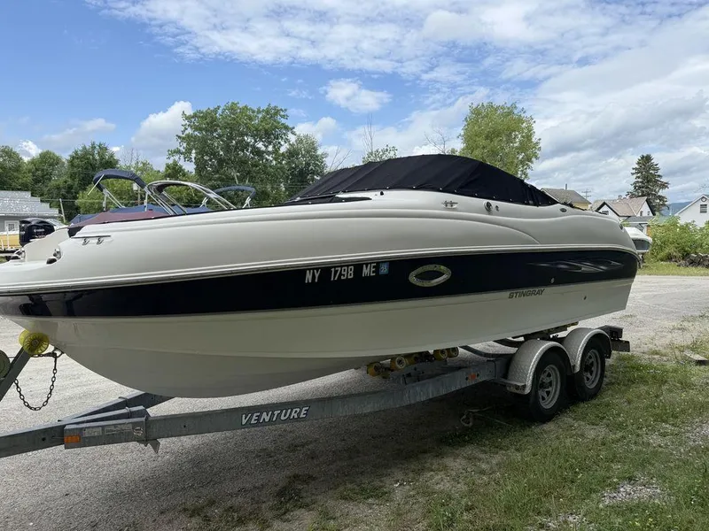 Slide: The Image of 2007 Stingray 220DR boat on trailer, parked outdoors under a partly cloudy sky. - 3