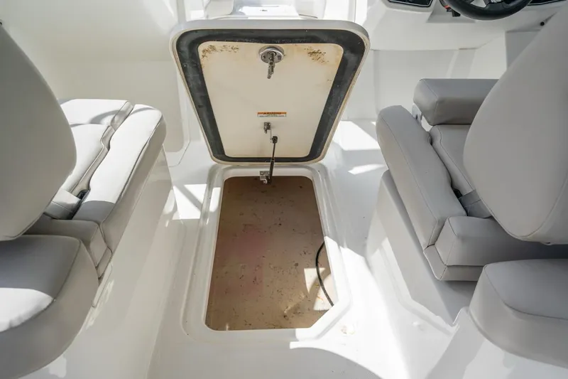 Slide: The Image of 2025 Hurricane SunDeck 2050 OB boat interior with open storage compartment and seating. - 7