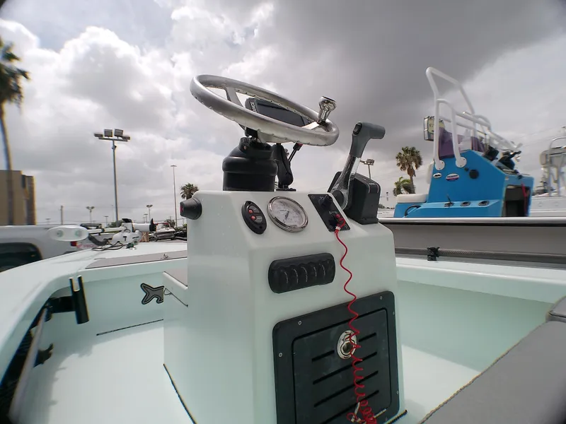 Slide: The Image of 2016 Ankona Copperhead boat console with steering wheel and controls under cloudy sky. - 10