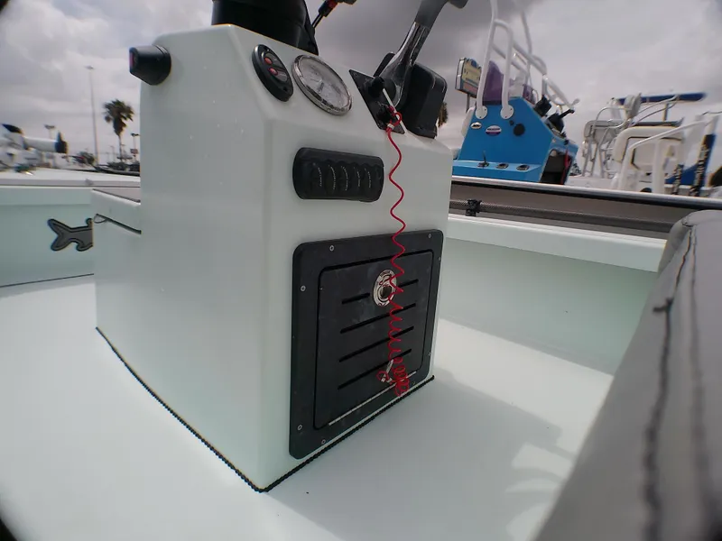 Slide: The Image of 2016 Ankona Copperhead boat console with gauges and controls, docked under cloudy skies. - 12