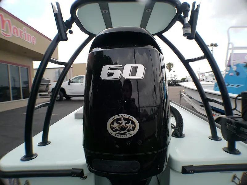 Slide: The Image of 2016 Ankona Copperhead boat with 60 HP engine, parked near a marine shop. - 19