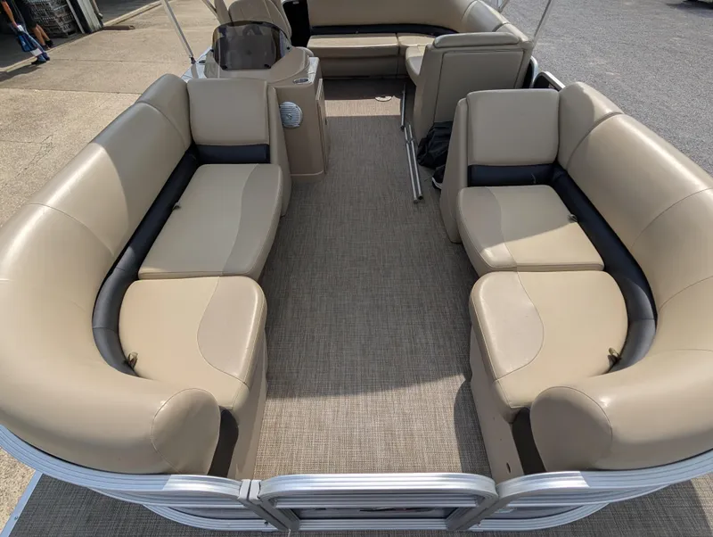 Slide: The Image of 2016 Manitou 23 Aurora pontoon boat interior with beige seating and carpeted floor. - 11