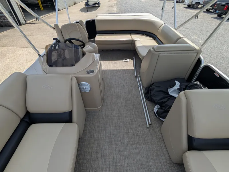 Slide: The Image of 2016 Manitou 23 Aurora pontoon boat interior with beige seating and steering console. - 12