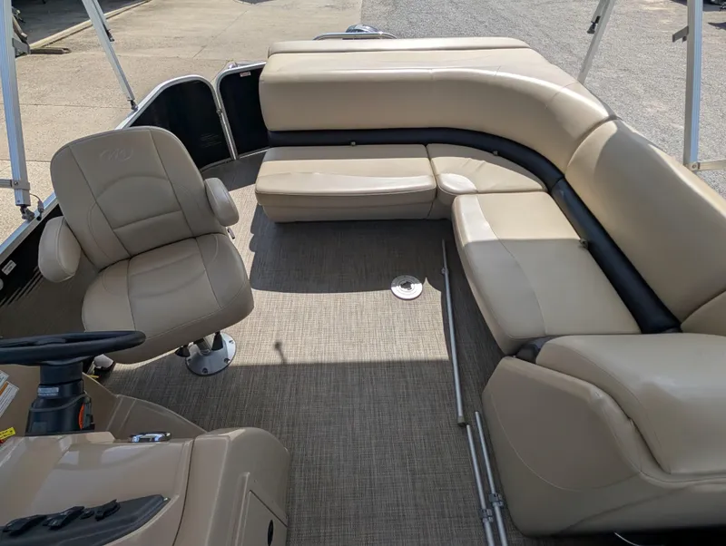 Slide: The Image of 2016 Manitou 23 Aurora boat interior with beige seating and steering console. - 13