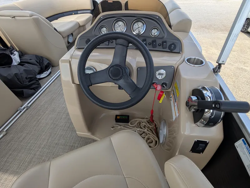 Slide: The Image of 2016 Manitou 23 Aurora boat dashboard with steering wheel and control panel. - 19
