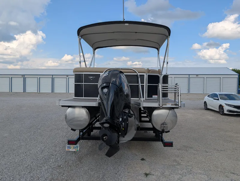 Slide: The Image of 2016 Manitou 23 Aurora pontoon boat with outboard motor, parked in storage area. - 7