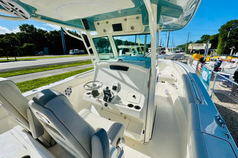 Slide: The Image of 2026 Sailfish 312 CC boat interior with helm, seats, and controls, displayed outdoors. - 4
