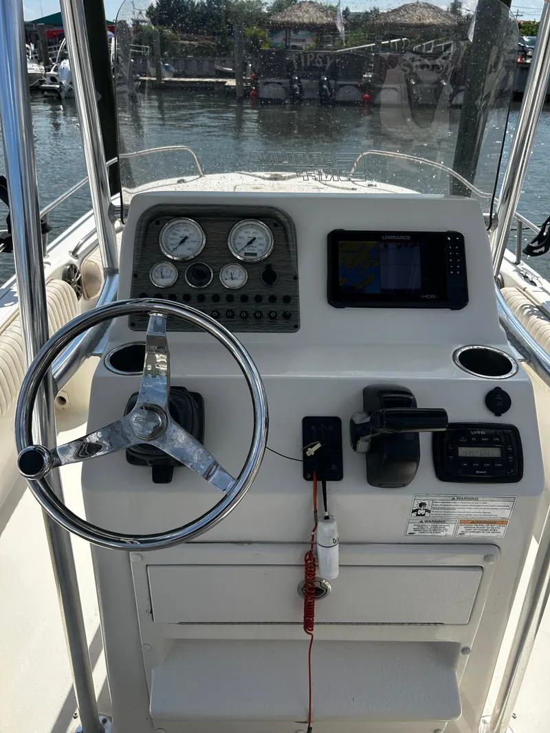 Slide: The Image of 2015 Carolina Skiff 21 Ultra Elite boat console with steering wheel and navigation controls. - 10