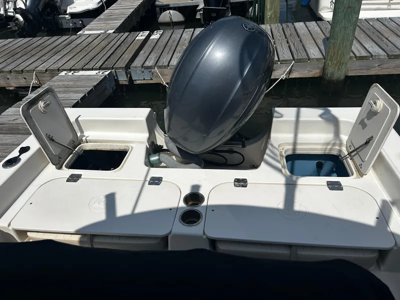 Slide: The Image of 2015 Carolina Skiff 21 Ultra Elite boat with open storage compartments at dock. - 22