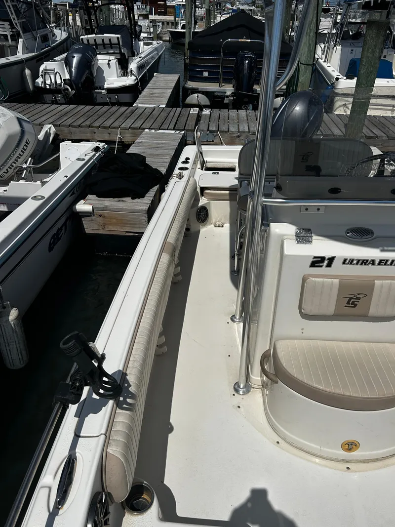 Slide: The Image of 2015 Carolina Skiff 21 Ultra Elite boat docked at marina, featuring spacious deck and seating. - 27