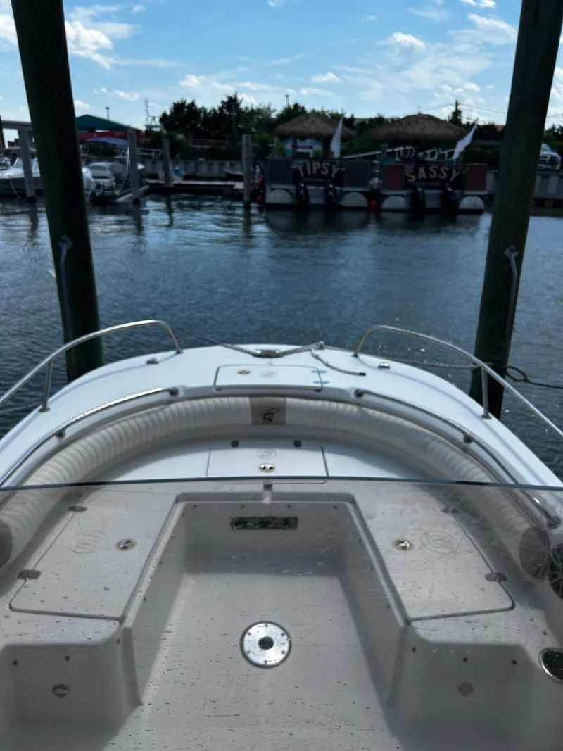 Slide: The Image of 2015 Carolina Skiff 21 Ultra Elite boat docked in a marina under a blue sky. - 28