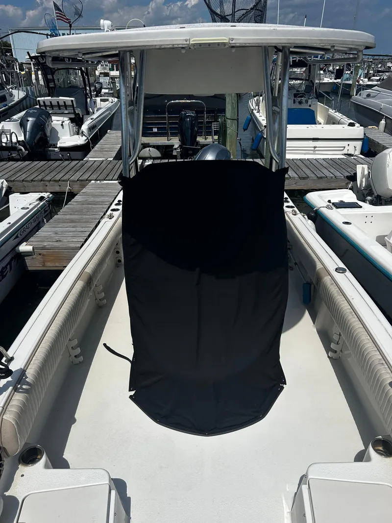 Slide: The Image of 2015 Carolina Skiff 21 Ultra Elite boat docked at marina, featuring T-top and spacious deck. - 6
