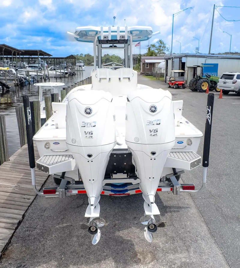 Slide: The Image of 2026 Tidewater 2700 Carolina Bay boat with dual outboard engines at a marina. - 10