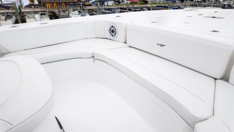 Slide: The Image of Luxurious seating on 2026 Tidewater 2700 Carolina Bay boat, featuring white upholstery and speaker system. - 28