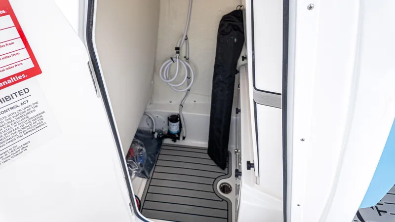 Slide: The Image of Interior view of 2026 Tidewater 2700 Carolina Bay boat compartment with equipment and warning label. - 31