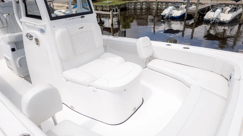 Slide: The Image of 2026 Tidewater 2700 Carolina Bay boat interior with white seating and console, docked by the water. - 8