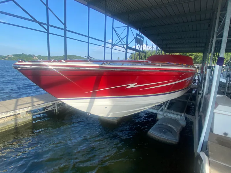 Slide: The Image of 2006 Formula 353 FASTech boat in red, docked under a covered marina. - 10