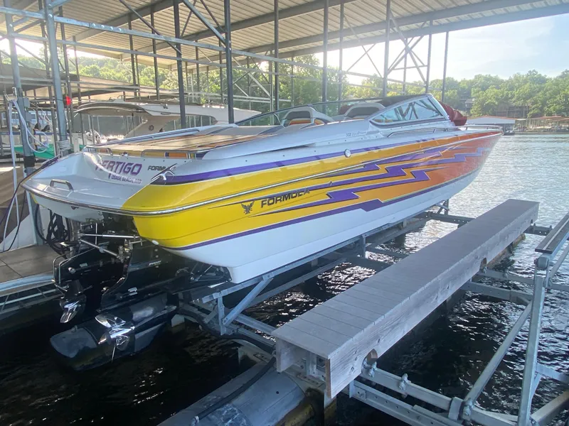 Slide: The Image of 2006 Formula 353 FASTech speedboat with vibrant graphics on a dock lift. - 12