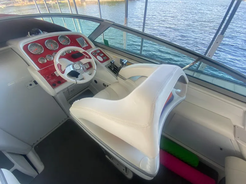 Slide: The Image of 2006 Formula 353 FASTech boat cockpit with white seats and red dashboard, overlooking water. - 19