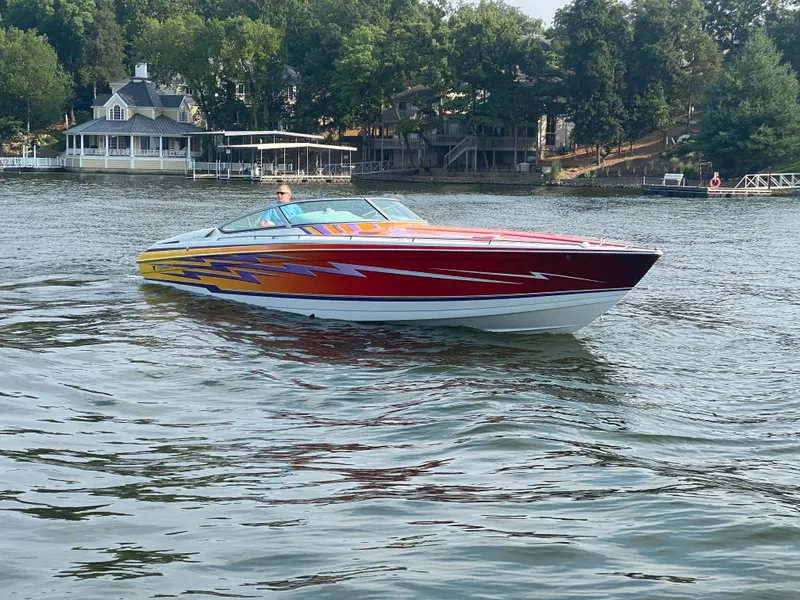 Slide: The Image of 2006 Formula 353 FASTech speedboat on a lake with vibrant graphics and scenic background. - 2