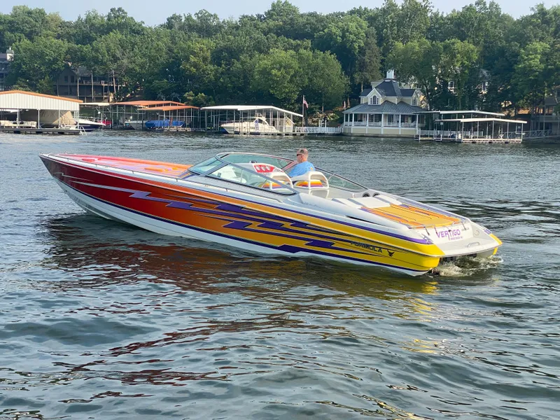 Slide: The Image of 2006 Formula 353 FASTech speedboat with vibrant graphics cruising on a lake. - 4