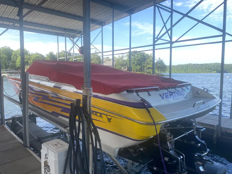 Slide: The Image of 2006 Formula 353 FASTech boat docked, covered with a red tarp, vibrant yellow and purple design. - 48
