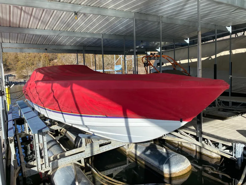 Slide: The Image of 2006 Formula 353 FASTech boat with red cover on a lift in a marina. - 51
