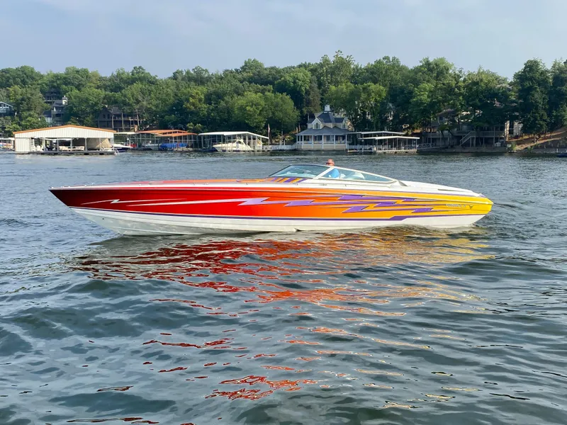 Slide: The Image of 2006 Formula 353 FASTech speedboat with vibrant red and yellow design on a lake. - 6