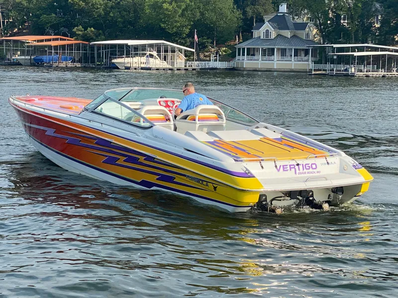 Slide: The Image of 2006 Formula 353 FASTech boat with vibrant graphics on a lake. - 7