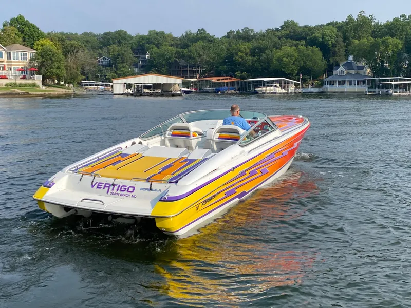 Slide: The Image of 2006 Formula 353 FASTech boat with vibrant graphics cruising on a lake. - 8